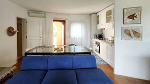 Un espace de vie compact comprenant un coin repas, une kitchenette et un canapé.