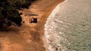 A beach with a small hut and a lifeguard tower. - Oliven Penthouse (Sutivan)