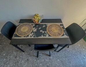 A table with two woven placemats, a basket with snacks, and a chair. - Il Sogno di Beatrice Luxury Apartment (Manarola)