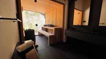 Un baño moderno con un espejo grande, paneles de madera y un banco.