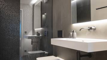 A modern bathroom with a shower, toilet, and sink.