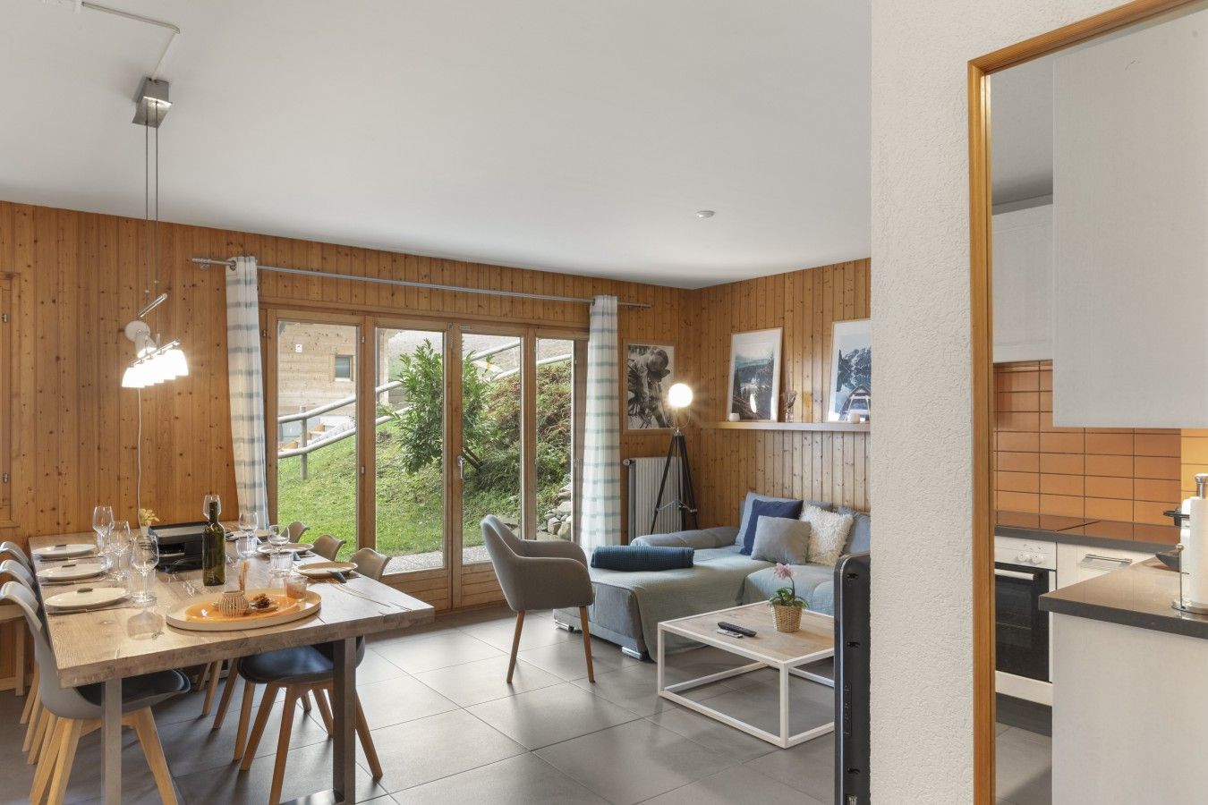 Un intérieur moderne comprenant un coin repas, un canapé et une cuisine.