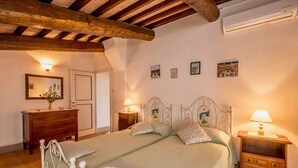 Ein Schlafzimmer mit einem großen Bett, zwei Nachttischen, einer Kommode und einem Spiegel.