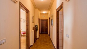 A narrow hallway with wooden doors and a radiator on the wall. - Agriturismo Case Graziani - Palazzo 2 (Citta della Pieve)