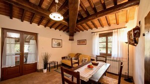 A cozy dining area with a wooden table, chairs, and a ceiling fan. - Agriturismo Malagronda - Pino (Citta della Pieve)