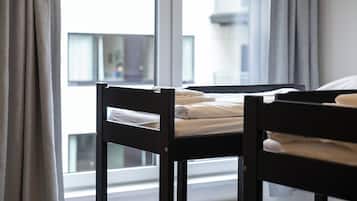 Una habitación con cama, ventana y cortinas.