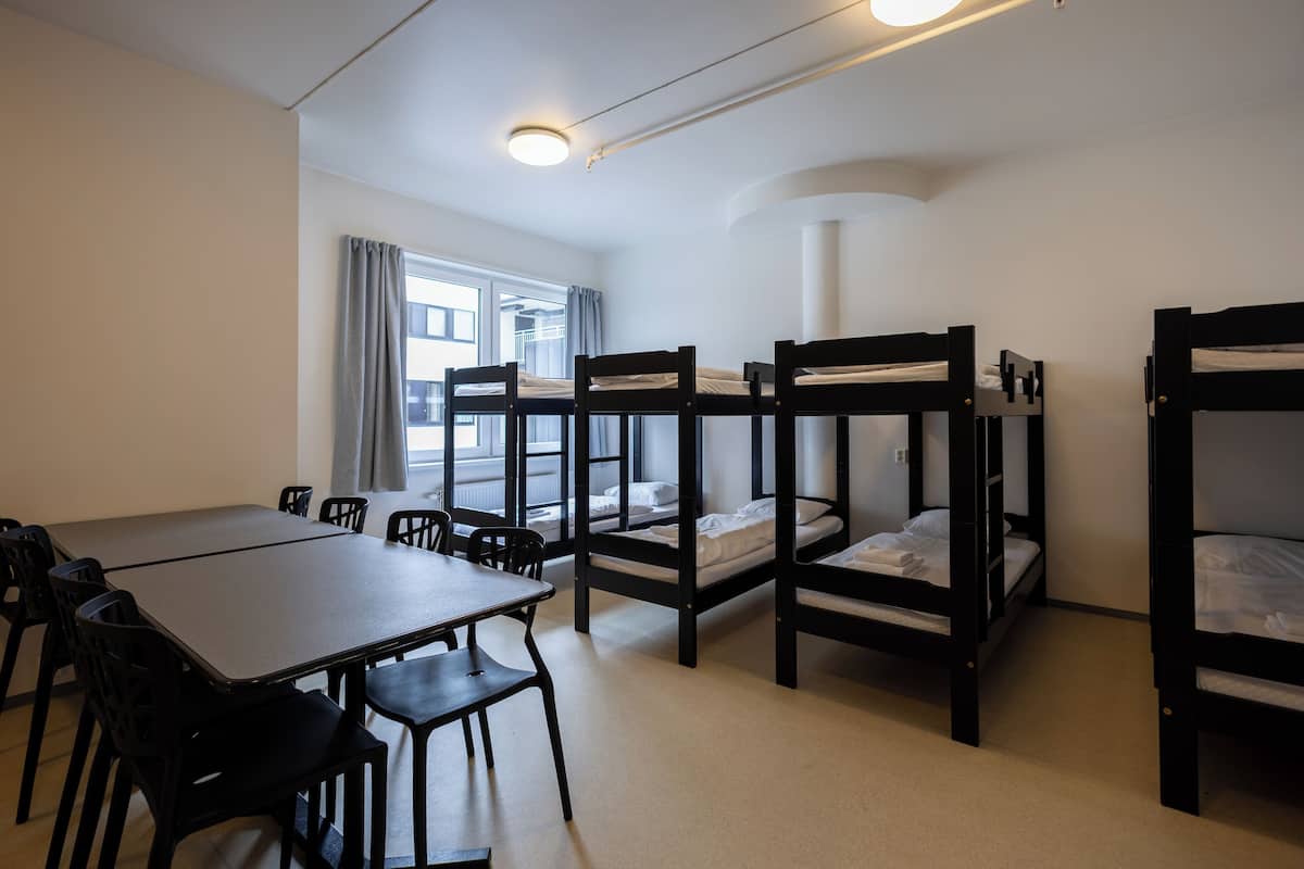 Un dormitorio con literas, una mesa de comedor y sillas.