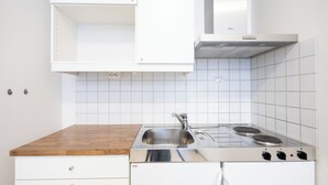 A kitchen with a stainless steel stove, a sink, and white cabinets.