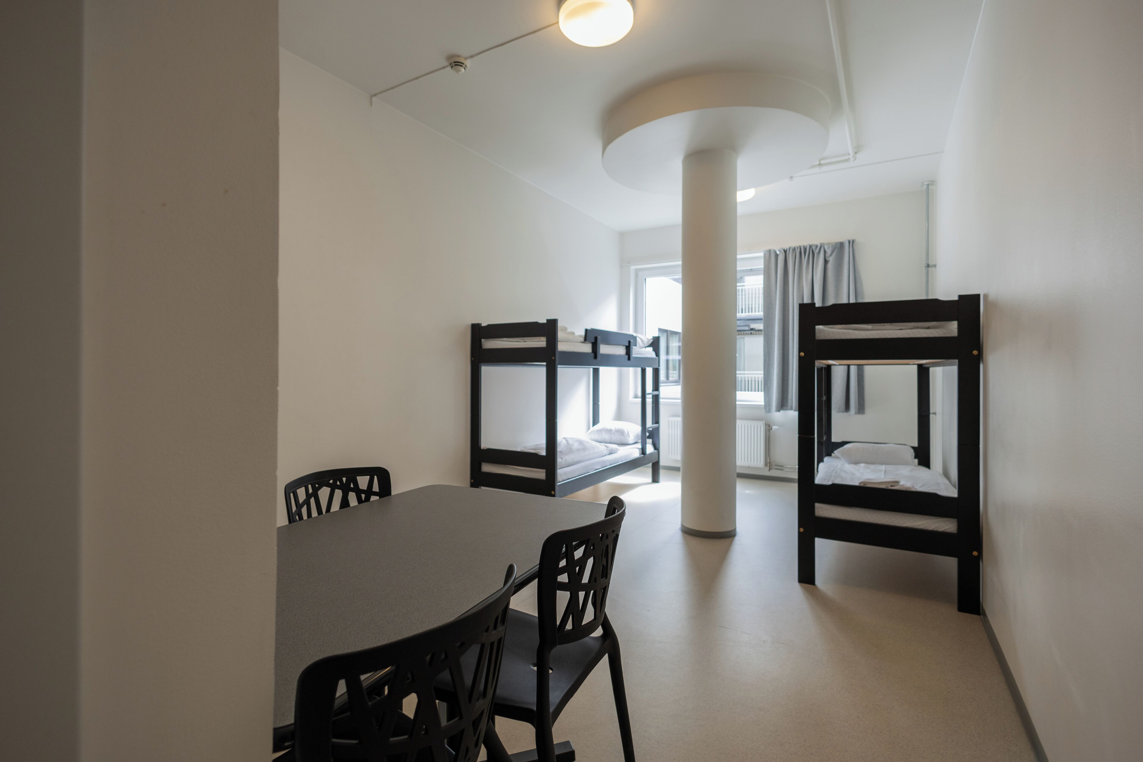 Ein Zimmer mit Etagenbetten, einem Esstisch und Stühlen.