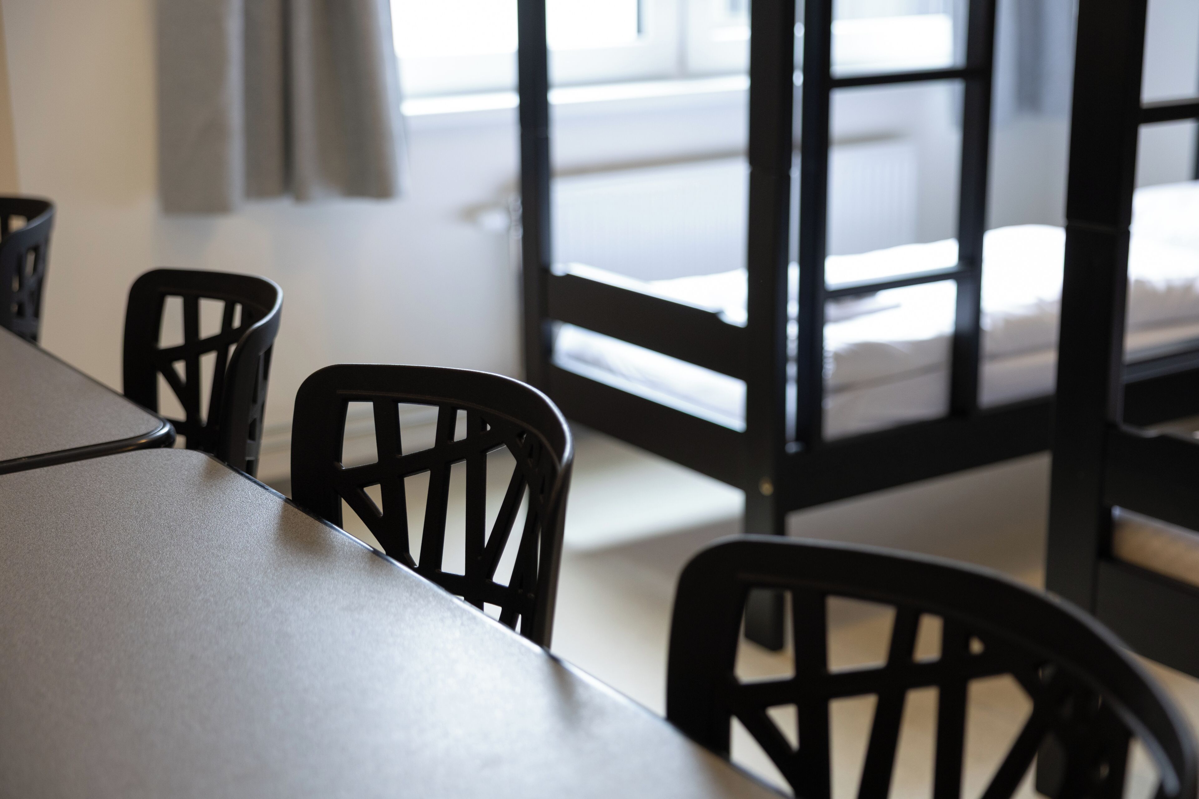 Una habitación con una cama, una mesa y sillas.