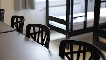 Una habitación con una cama, una mesa y sillas.
