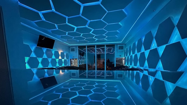 A modern hotel lobby with a geometric ceiling design and a reflective floor. - Hôtel Sana (Abidjan)