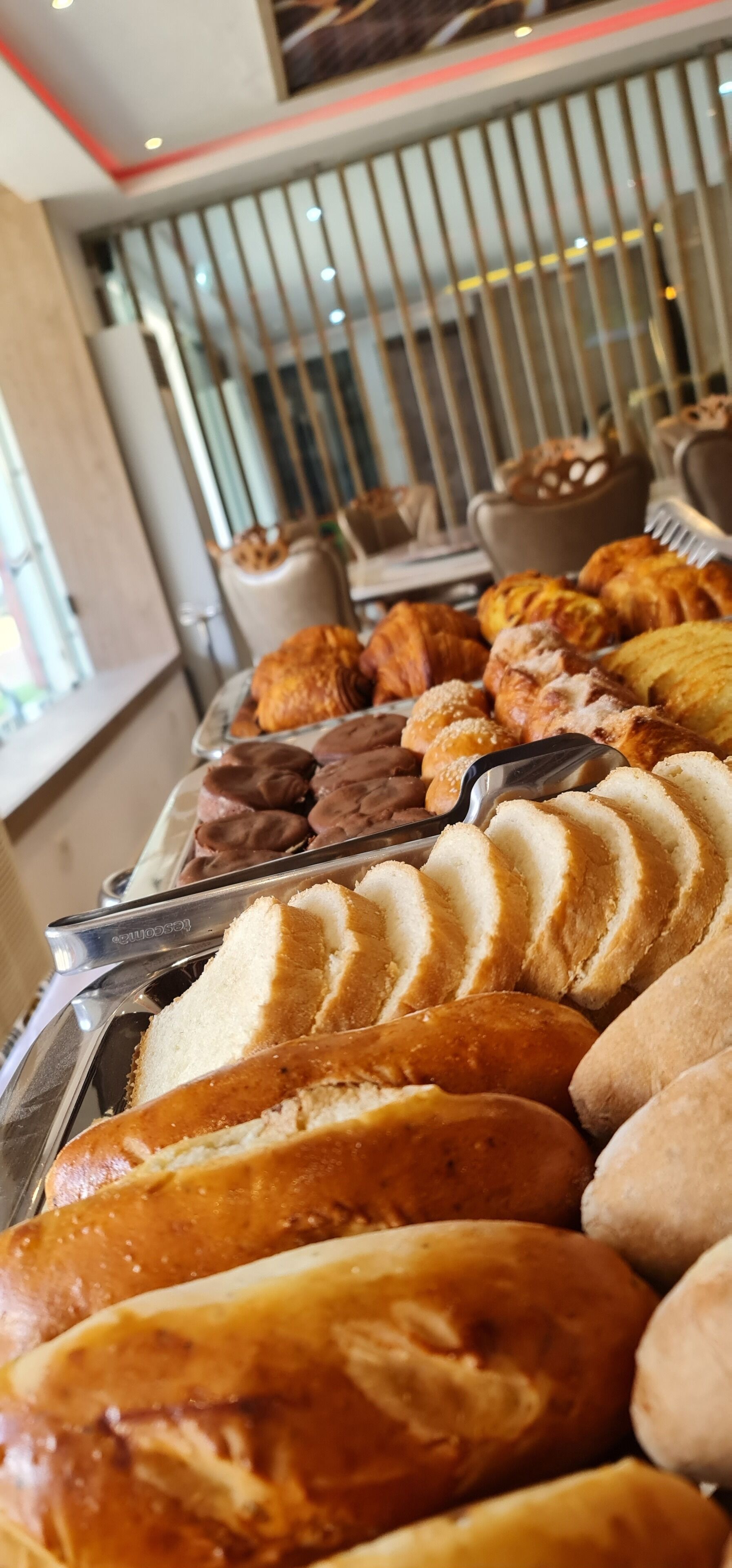 A buffet with various baked goods including bread, pastries, and cookies.