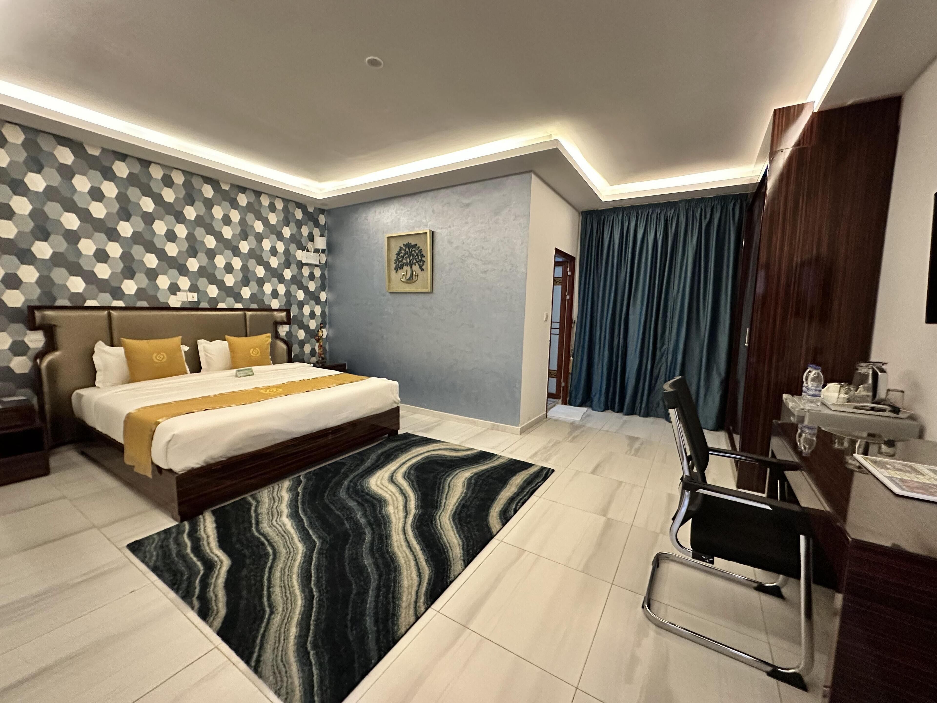 Una habitación de hotel moderna con una cama grande, un escritorio y una silla.
