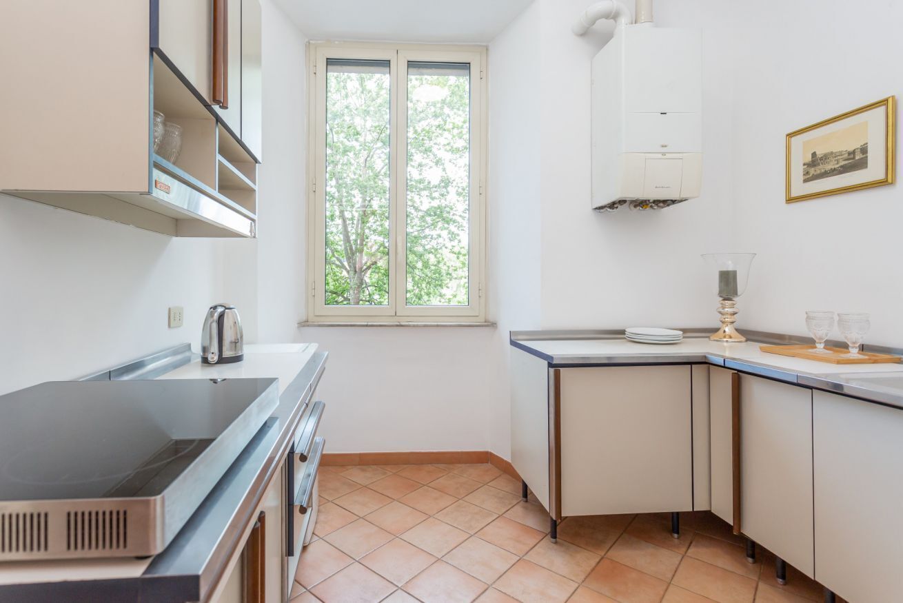 A small kitchen with a window, a stove, and a sink.