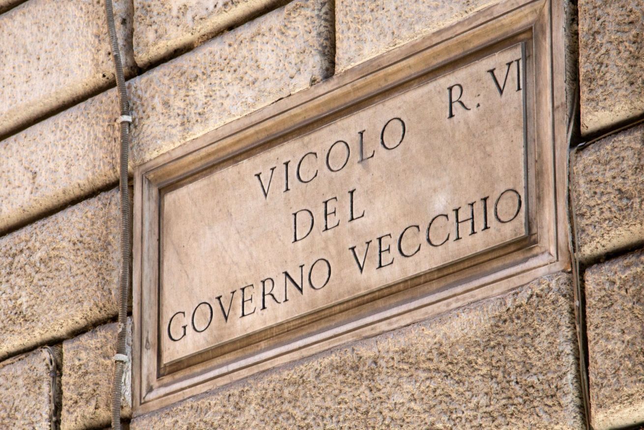 A stone plaque with the inscription "VICOLO R. VI DEL GOVERNO VECCHIO".