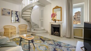 A modern living room with a spiral staircase, a fireplace, and a view of a historic building. - Daplace - Mirta Apartment (Roma)