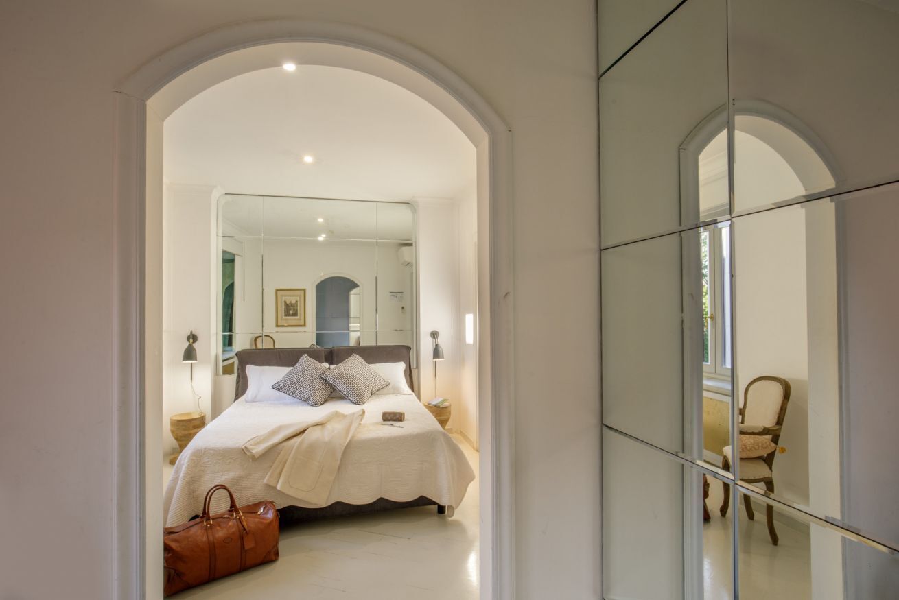 Ein Schlafzimmer mit Bett, Spiegel und Stuhl.