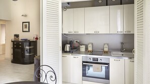 A compact kitchen with white cabinets, a built-in oven, and a coffee maker. - Easylife - Jewel of art in Arco della Pace area (Milano)