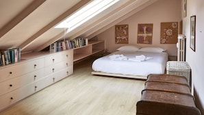 A bedroom with a sloped ceiling, a bed with white linens, a dresser, and a bookshelf. - Easylife - Jewel of art in Arco della Pace area (Milano)