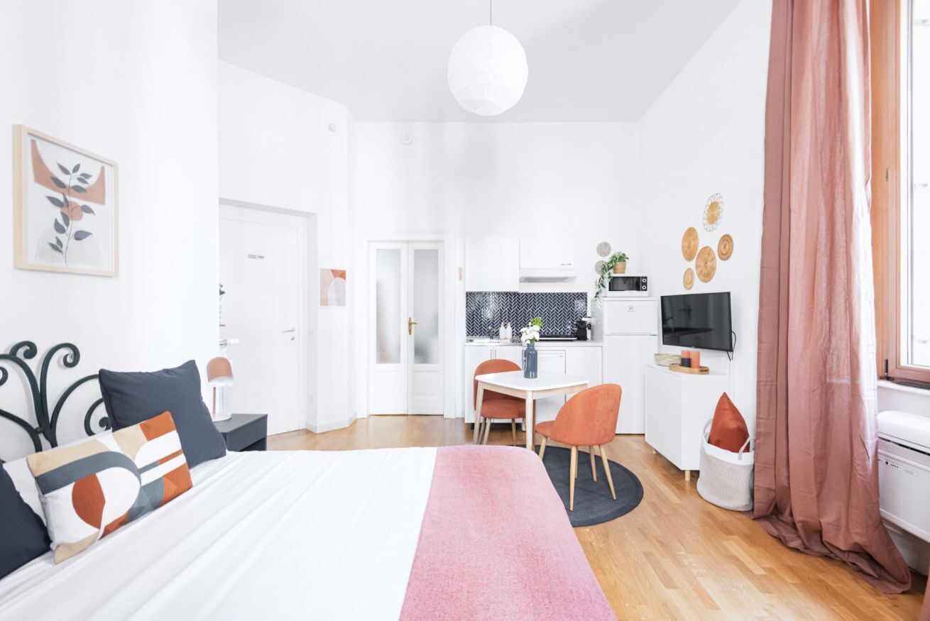 Une chambre d’hôtel moderne équipée d’un lit, d’un bureau et d’une télévision.