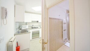A kitchen with white cabinets, a microwave, a kettle, and a stove. - DolceVita Apartments N. 465 (Venice)
