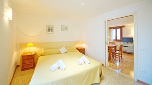 A hotel room with a bed, bedside lamps, a desk with a chair, and a television. - DolceVita Apartments N. 465 (Venice)