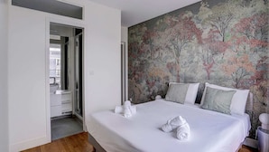 A hotel room with a large bed, a bathroom with a sink, and a door leading to a hallway. - Bright Etoile /  Bright 2 bed close to Eiffel Tower Arc the Triomphe et Champs E (Paris)