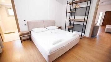 A bedroom with a bed, bedside tables, a wardrobe, and a ladder.