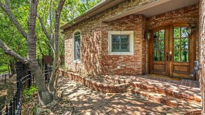 A brick house with a front porch, a wooden door, and a window.