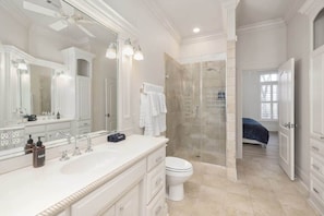 Un baño con un espejo grande, una ducha y un inodoro.