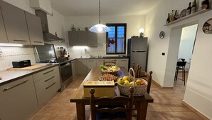 Une cuisine moderne dotée d’un îlot central, de chaises en bois et d’une table à manger pouvant accueillir six personnes.