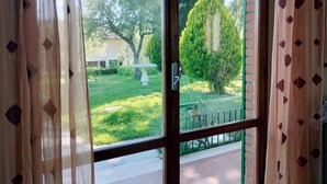 A view through a window with a wooden frame and a door handle.
