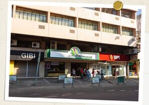 A hotel with a green and white sign, a BP1 gas station, and a GIBI store. - Etsu Hotel (Tacloban)