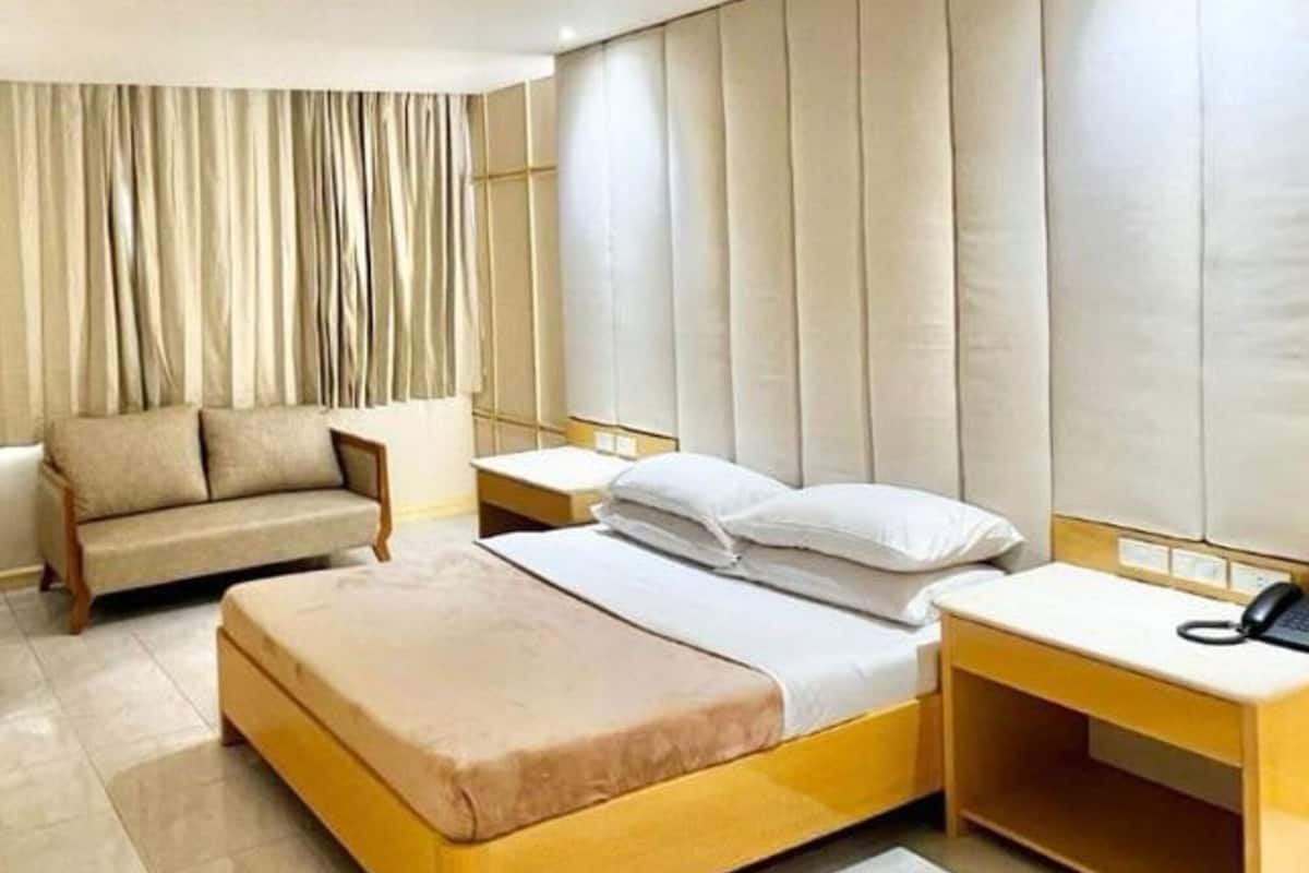 Ein Hotelzimmer mit einem Bett, einer Couch und einem Nachttisch mit Telefon.
