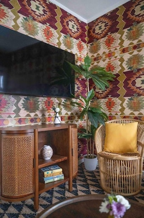 Relax in style with a flat-screen TV, wicker chair, and potted plant.