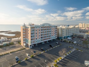 Et hotel med flere etager, parkeringsplads og udsigt til vandet.