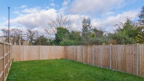 A fenced backyard with a grassy lawn. - 2BR Gem, Parking & Garden - VAT Q - By Tempstay (Berkshire)