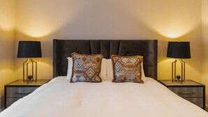 A hotel room with a large bed, two nightstands, and two lamps. - 2BR Gem, Parking & Garden - VAT Q - By Tempstay (Berkshire)