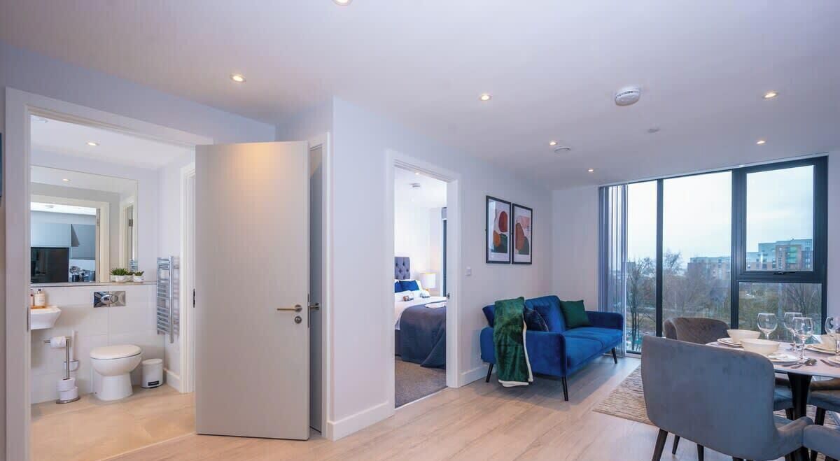 Un apartamento moderno con cocina, comedor y sala de estar con un amplio ventanal.