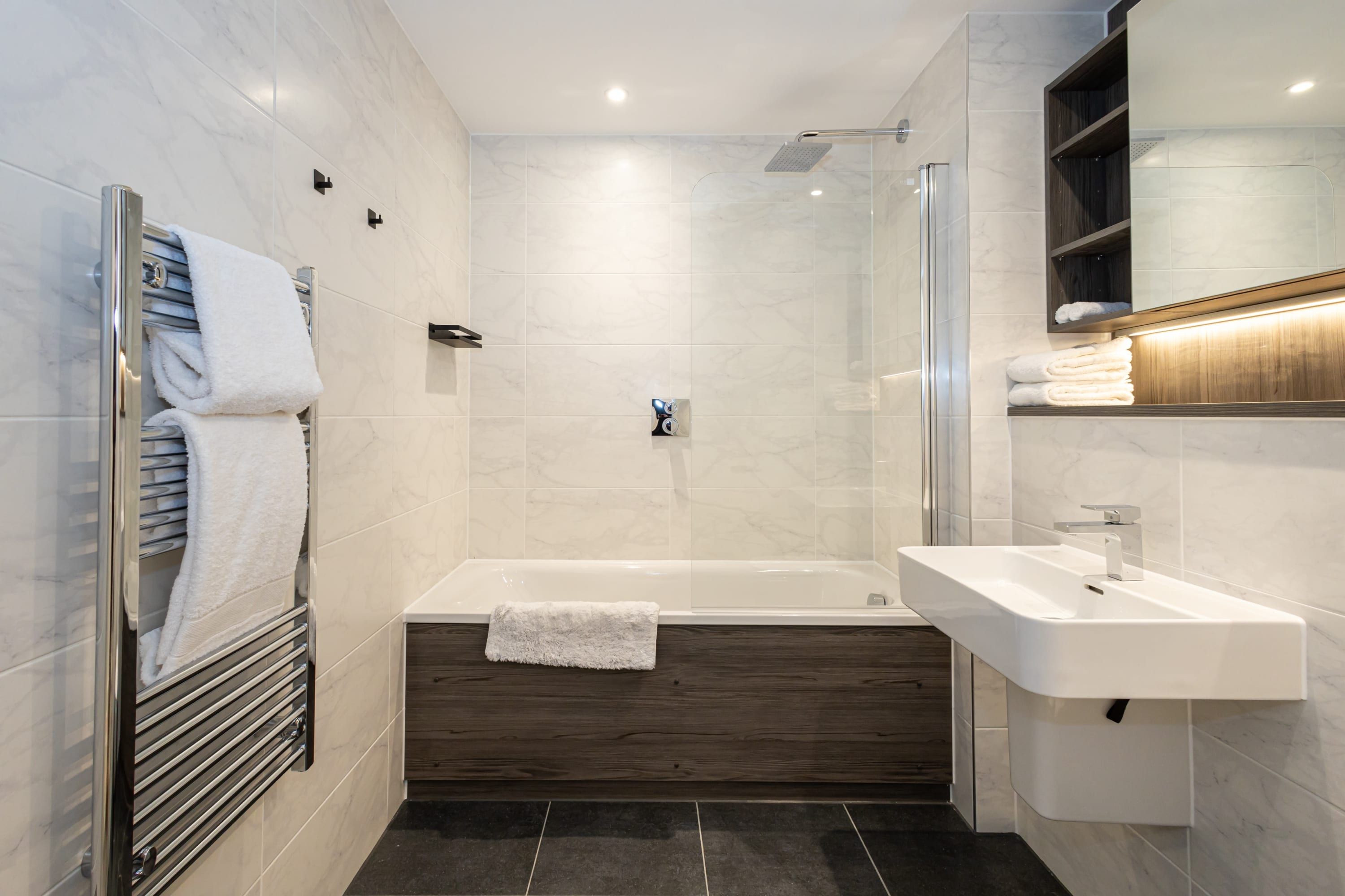 A modern bathroom with a bathtub, a shower, and a sink.