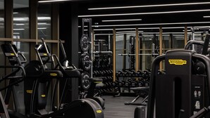 Une salle de sport équipée de tapis de course, d’appareils de musculation et de poids libres.