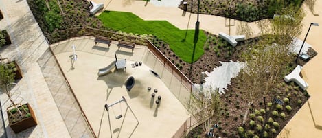 Un patio de juegos con tobogán, columpios y una estructura para escalar.