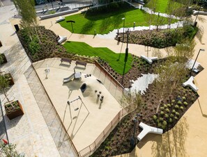 Un patio de juegos con tobogán, columpios y una estructura para escalar.