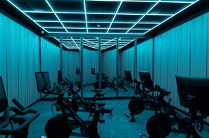 Ein Raum mit Spiegelwänden, Deckenleuchten und Ergometer.