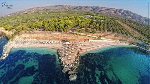 An aerial view of a coastal area with a beach, a small building, and a mountainous backdrop. - Hotel Relais dei Normanni (Monte Sant'Angelo)