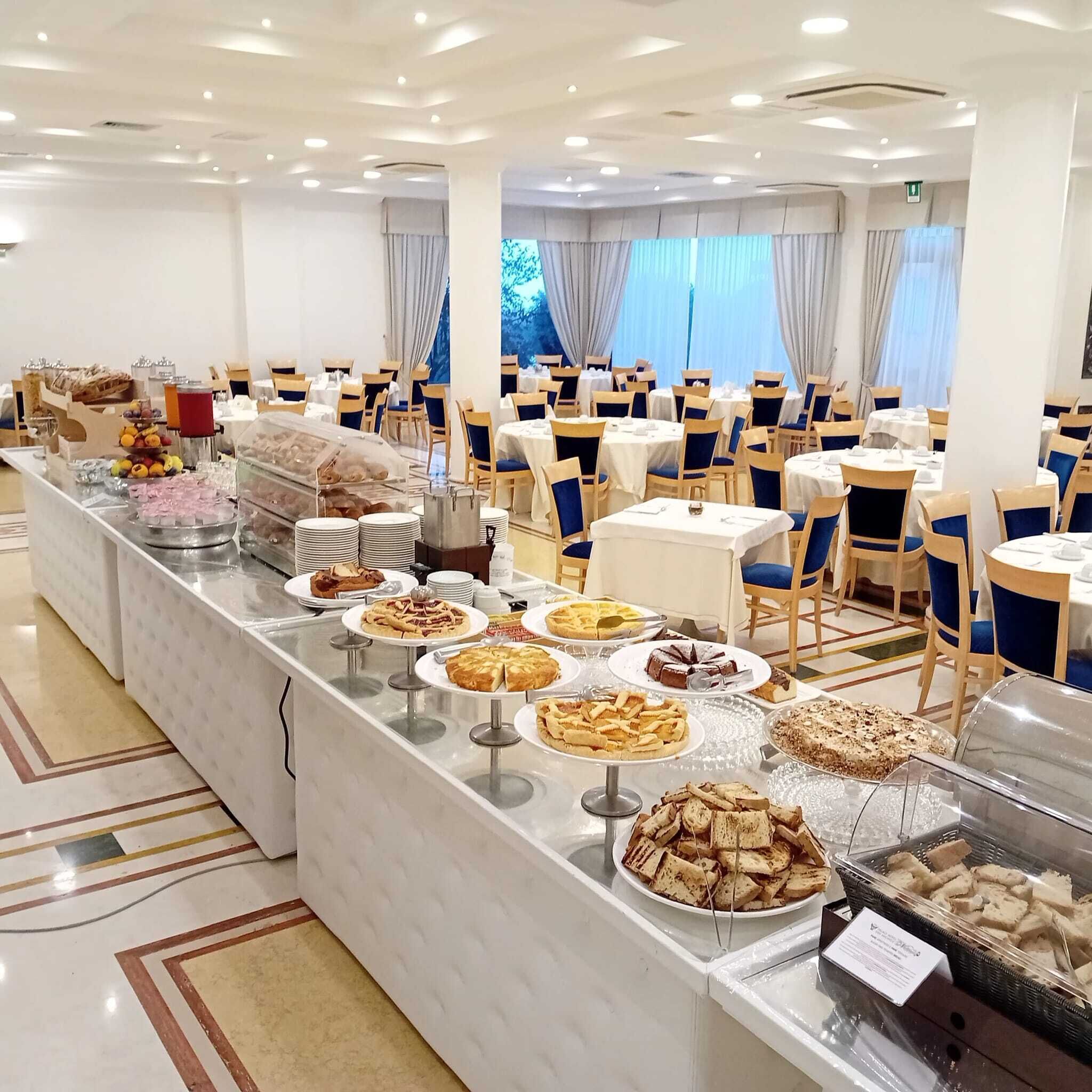 Un buffet proposant une variété de plats et un espace avec des tables et des chaises où les convives peuvent s’asseoir.