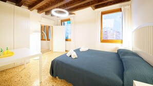 Une chambre à coucher avec un lit, un bureau et une fenêtre avec des rideaux.