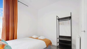 Un dormitorio con cama, armario y radiador.