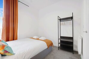 Un dormitorio con cama, armario y radiador.